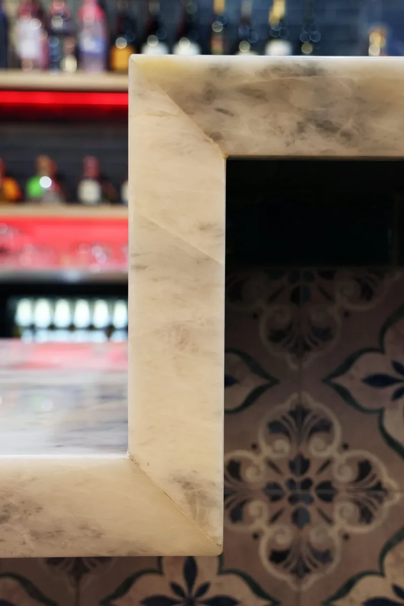 Detail of the stone bar top edge and patterned tile