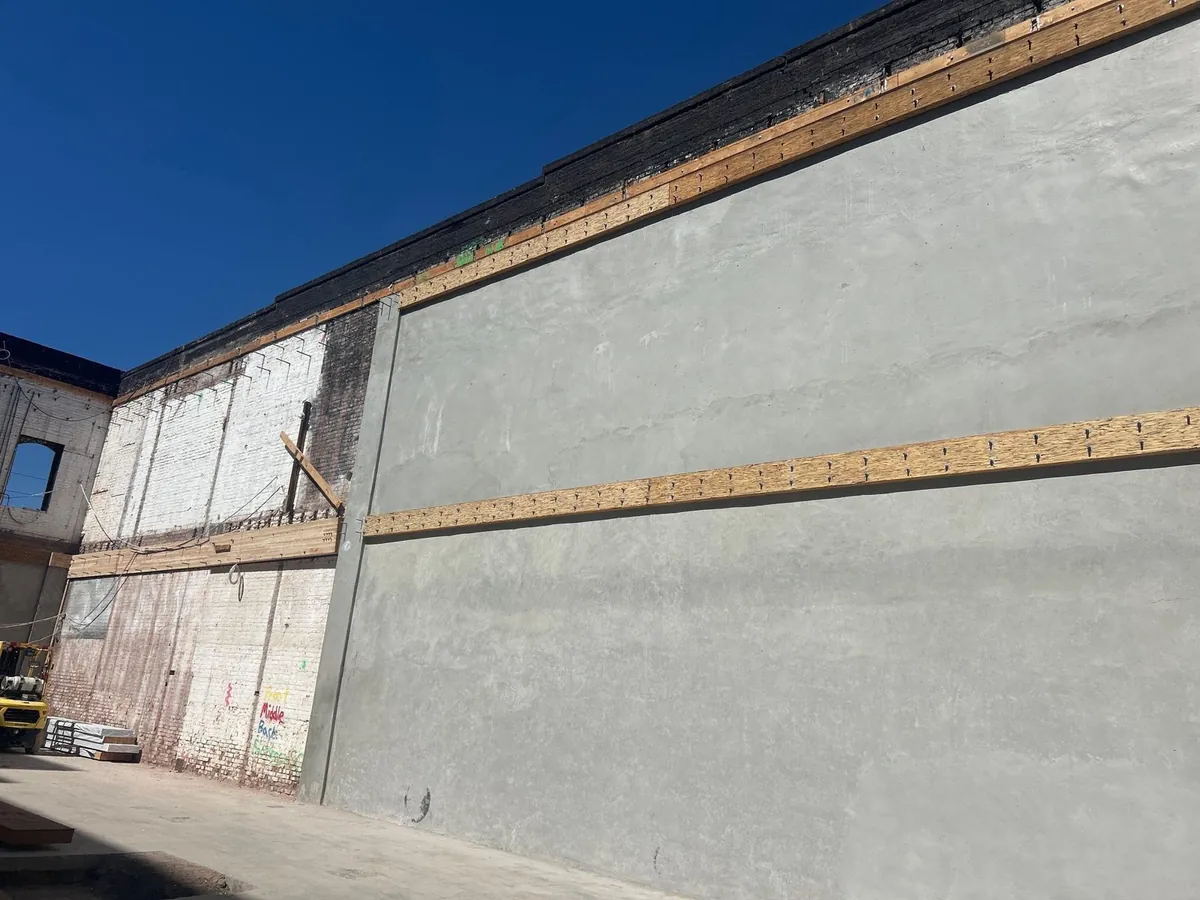 New shotcrete shear wall applied to the inside of the brick wall